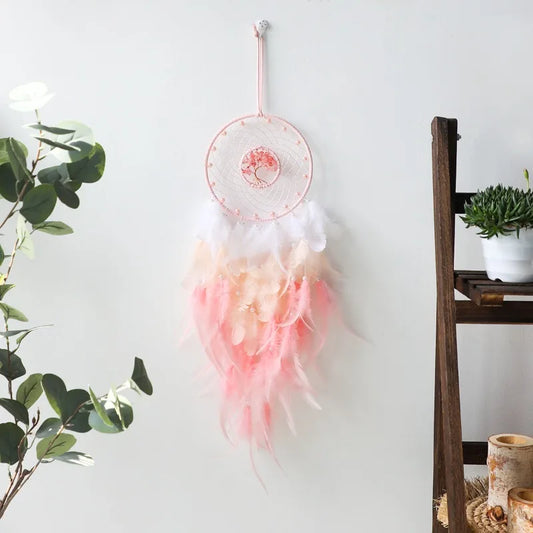 Détail des plumes roses et blanches de l'attrape-rêve artisanal, cordons tressés