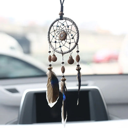 Attrape-rêve plumes 30 cm suspendu au-dessus d'un lit, ambiance chambre naturelle