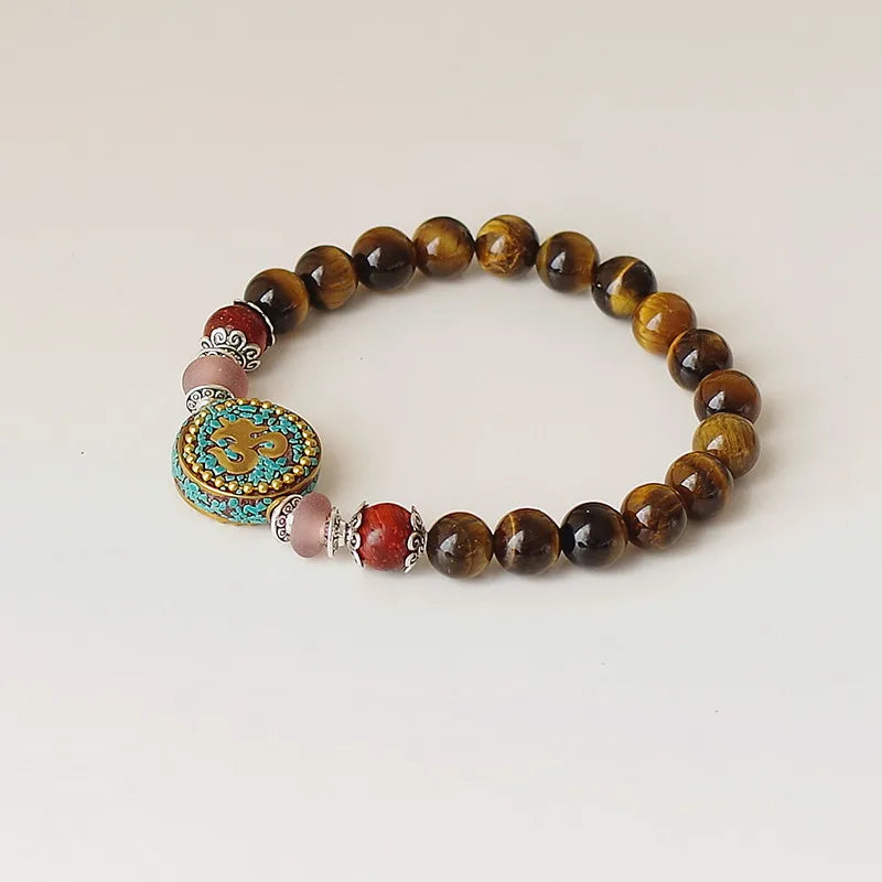 Bracelet tibétain Om porté au poignet perles oeil de tigre ambré
