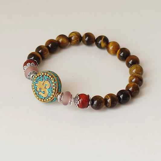Bracelet tibétain Om oeil de tigre perles rondes dorées sur fond clair