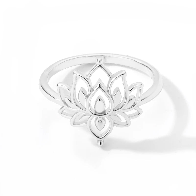 Bague lotus bouddhiste dorée posée sur surface naturelle, vue de profil