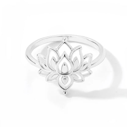 Bague lotus bouddhiste dorée posée sur surface naturelle, vue de profil