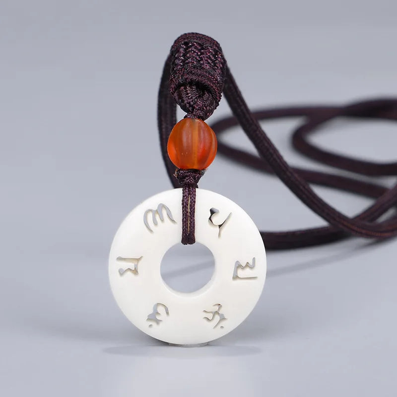 Collier pendentif tibétain ivoire synthétique motif vajrayâna gravé vue face