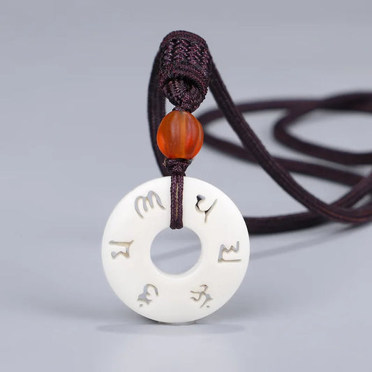 Collier pendentif tibétain ivoire synthétique motif vajrayâna gravé vue face